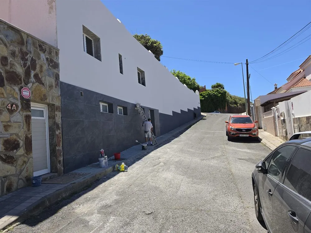 Fachada rehabilitada y pintada con zócalo gris en una vivienda de Las Palmas de Gran Canaria