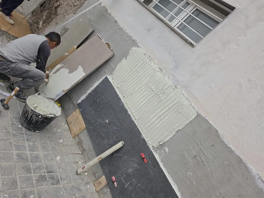 Colocación de plaqueta en el zócalo de una fachada en Las Palmas de Gran Canaria