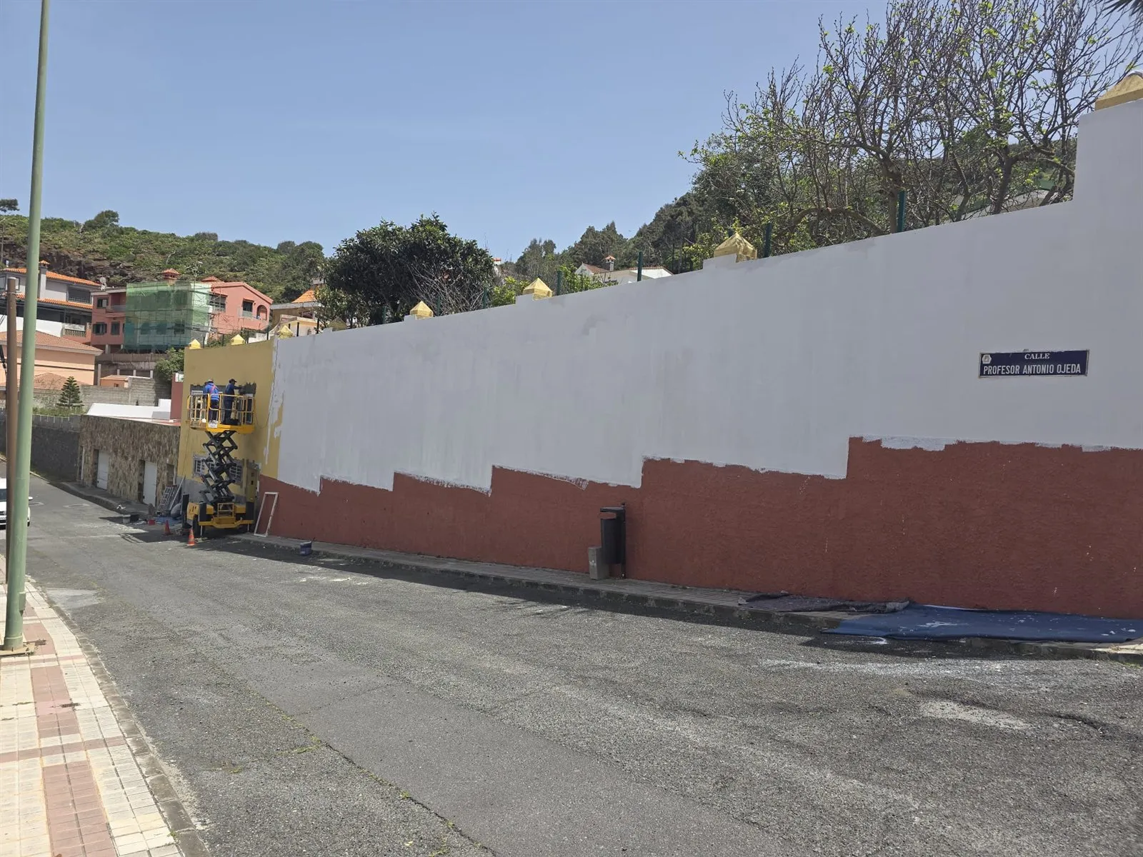 Operarios rehabilitando un muro en altura con plataforma elevadora en Las Palmas de Gran Canaria